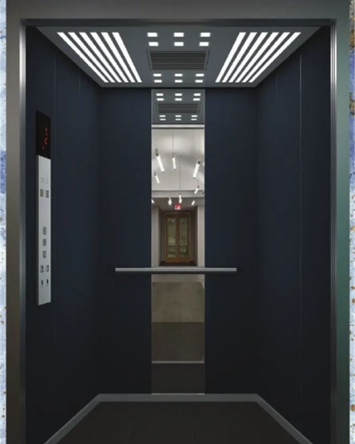 A navy blue lift cabin with a linear lit ceiling and a stainless handrail