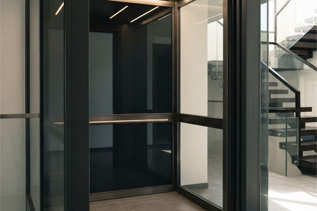 A dark glass and steel lift cabin